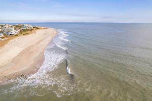 een luchtzicht op een strand met huizen en de oceaan bij Chasing Waves Luxury Edisto Home 3 mins to Beach in Edisto Island