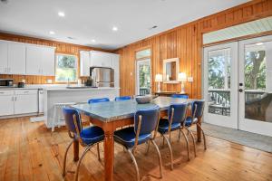 een keuken met een tafel en blauwe stoelen bij Chasing Waves Luxury Edisto Home 3 mins to Beach in Edisto Island +52 foto's