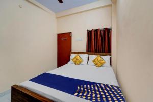 a bedroom with a bed with blue and yellow pillows at SPOT ON RKH Inn in Chennai