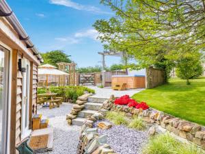 a backyard with a stone pathway and a garden with red flowers at 1 Bed in Bodmin 88049 in Luxulyan