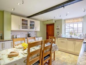 a kitchen with a table and some chairs and a table and a kitchen with at 3 Bed in Sawrey 62587 in Far Sawrey