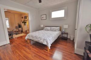 1 dormitorio con 1 cama y suelo de madera en The Columbus Hideaway Den, en Columbus