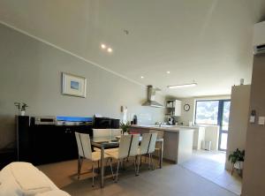 a kitchen and living room with a table and chairs at Mount Stunner with King Beds in Mount Maunganui