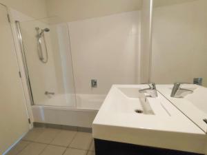 a white bathroom with a sink and a shower at Mount Stunner with King Beds in Mount Maunganui