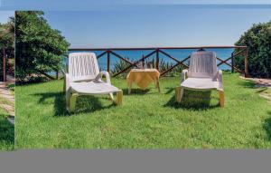 two chairs sitting in the grass near the ocean at Gorgeous Home In Menfi Ag With Wifi in Porto Palo