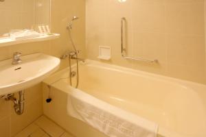 a bathroom with a sink and a bath tub and a sink at Kurashiki Kokusai Hotel in Kurashiki