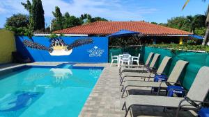 una piscina con sillas, una mesa y una valla en Las Catalinas Coronado, en Playa Coronado