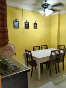 a dining room with a white table and chairs at Homestay Cikgu in Pasir Gudang