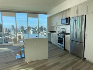 a kitchen with white cabinets and a view of the city at Massive Penthouse Overlooking All of San Diego in San Diego