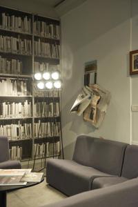una sala de estar con sofá y estanterías de libros en Hotel dei Gonzaga, en Mantua