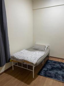 a small bed in a corner of a room at Sekeping Sandakan in Sandakan