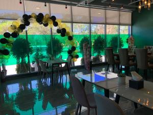 a dining room with tables and chairs and a large window at The Clover Hotel in Angeles