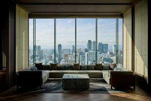 名古屋市にあるザ ロイヤルパークホテル アイコニック 名古屋のソファと大きな窓のある広いリビングルーム