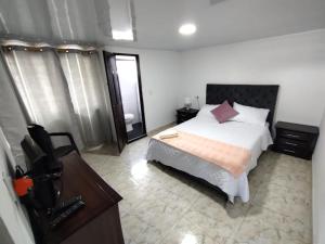 a bedroom with a bed and a dresser and a mirror at lindo apartamento cerca ala Basílica buga in Buga