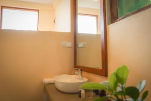 een badkamer met een wastafel en een spiegel bij Rock n Fall Nature Resort in Ella