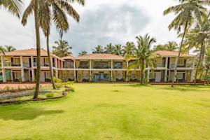 an exterior view of a resort with palm trees at Nilaya Stays in Padubidri