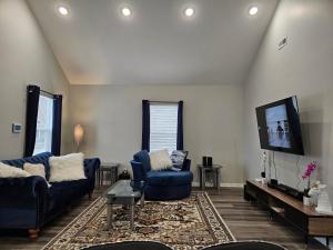 uma sala de estar com dois sofás azuis e uma televisão em New 3BD Home Near Downtown Indy em Indianápolis