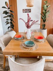 a wooden table with plates and wine glasses on it at Madrigal Luxury Penthouse in Florencia