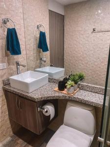 La salle de bains est pourvue d'un lavabo et de toilettes. dans l'établissement Madrigal Luxury Penthouse, à Florencia