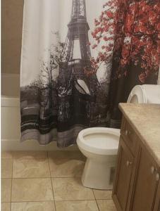 a bathroom with a toilet and a shower curtain with the eiffel tower at Luxury Room in Mississauga
