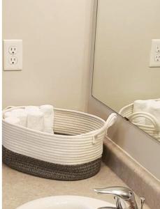 a bathroom with a mirror and a basket of towels at Luxury Room in Mississauga