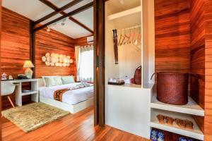 1 dormitorio con paredes de madera, 1 cama y escritorio en Viangviman Luxury Resort, Krabi, en Ao Nang Beach