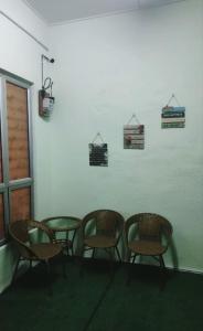 マスジッド・タナにあるPengkalan Sayangku Homestay islamの壁のある部屋(椅子4脚、テーブル1台付)
