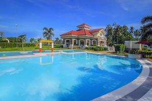 a large swimming pool in front of a house at 12 Guests l 4BR I Mins to City Centre l Karaoke l Swimming Pool in Tagum