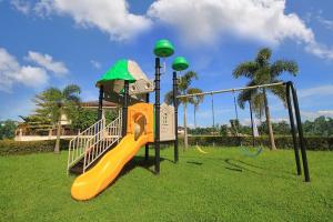 a playground with a slide in a park at Modern Home 4BR:Pool, Bathtub, Karaoke, Fast WIFI in Tagum