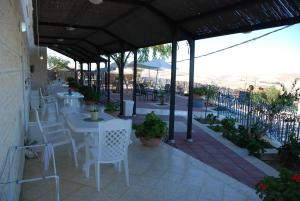 a restaurant with white tables and chairs on a patio at Villa 1000 in Arad +12 photos