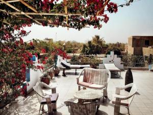 an outdoor patio with chairs and tables and flowers at Maison d'hôtes Chez Giuliana in Ouagadougou