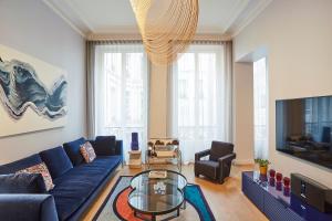 a living room with a blue couch and a glass table at Designer luxury flat in Central Paris - 2bed 2bath with AC in Paris