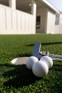 eine Gruppe von Golfschlägern und Bällen auf dem Rasen in der Unterkunft The Taj Of The Gulf! Luxury Beach Mansion! Sleeps 37, private pool & hot tub, putting golf in Panama City Beach