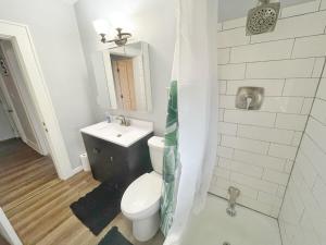een badkamer met een wit toilet en een wastafel bij The Columbus Den - Enjoy 3 BRs in the Upper Deck! in Columbus