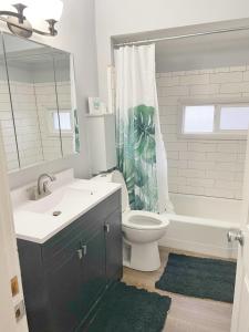 een badkamer met een wastafel, een toilet en een bad bij The Columbus Den - Enjoy 3 BRs in the Upper Deck! in Columbus