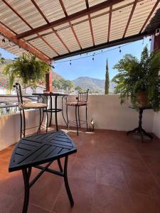 un patio con sillas y mesas en un balcón en Casa Geranios Antigua, en Antigua Guatemala