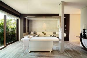 a bath tub in a bathroom with a large window at Jumeirah Bali in Uluwatu