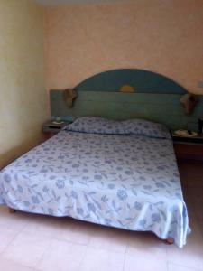 a bedroom with a bed with a blue and white comforter at Princess des Iles in Sainte-Anne