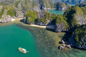 an island with a boat in a body of water at Cat Ba Violet Hotel in Cat Ba