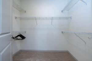 a walk in closet with white walls and metal shelves at Modern Nulu 2BR CozySuites 05 in Louisville