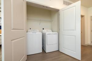 a laundry room with two washes and a door at Modern Nulu 2BR CozySuites 05 in Louisville