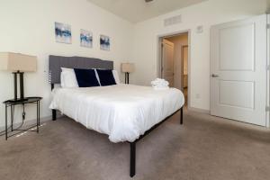 a bedroom with a large bed with white sheets at Stunning Nulu 1BR CozySuites 05 in Louisville