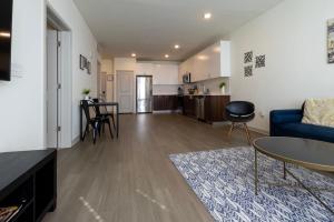 a living room with a blue couch and a kitchen at Stunning Nulu 1BR CozySuites 05 in Louisville