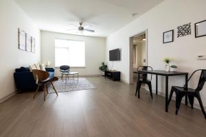 a living room with a table and chairs at Stunning Nulu 1BR CozySuites 05 in Louisville