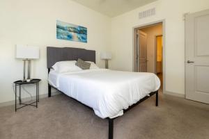 a bedroom with a large white bed and two lamps at Stunning Nulu 1BR CozySuites 06 in Louisville