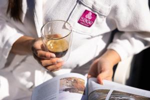 una mujer sosteniendo una copa de vino y un libro en Sage Hotel James Street, en Brisbane