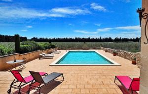 einen Pool auf einer Terrasse mit Stühlen und einem Tisch in der Unterkunft Le Temps Perdu in Maussane-les-Alpilles