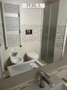 a bathroom with a sink and a toilet and a mirror at Residence Lori in Brindisi