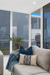 a couch with pillows on it in a living room at Ocean Vista Escape - A Lofty Beachfront Penthouse in Wollongong