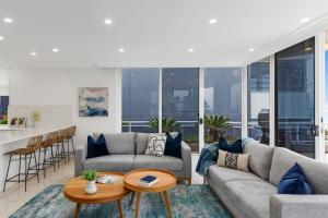 a living room with a couch and a table at Ocean Vista Escape - A Lofty Beachfront Penthouse in Wollongong
